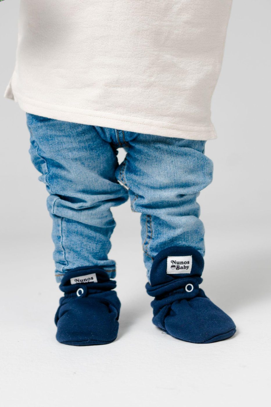 Bebé de pie con zapatos Nunos azules
